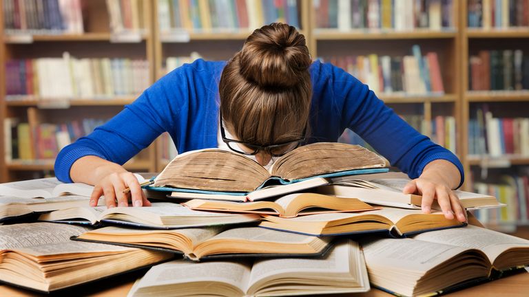 student sleeping on books