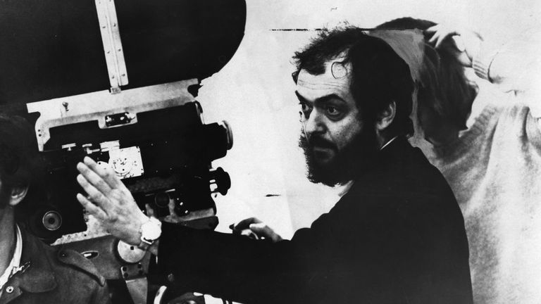 Stanley Kubrick looking through a movie camera